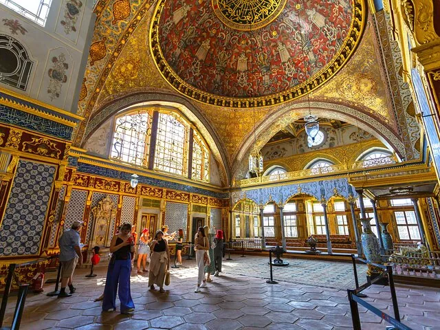 Touristen bewundern die kunstvolle Innenausstattung eines historischen Palastraums