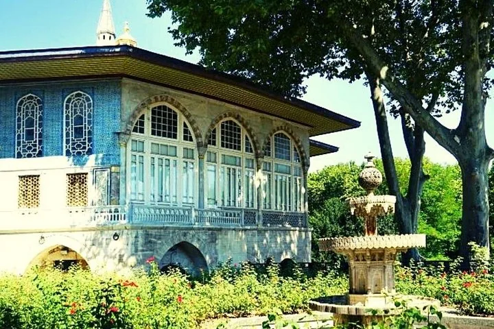 Baghdad Pavilion with blue tiles and stained glass windows viewed from the gardens