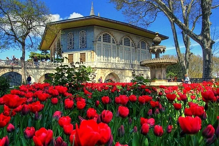 Bagdad-Pavillon und ein Brunnen, umgeben von blühenden roten Tulpen